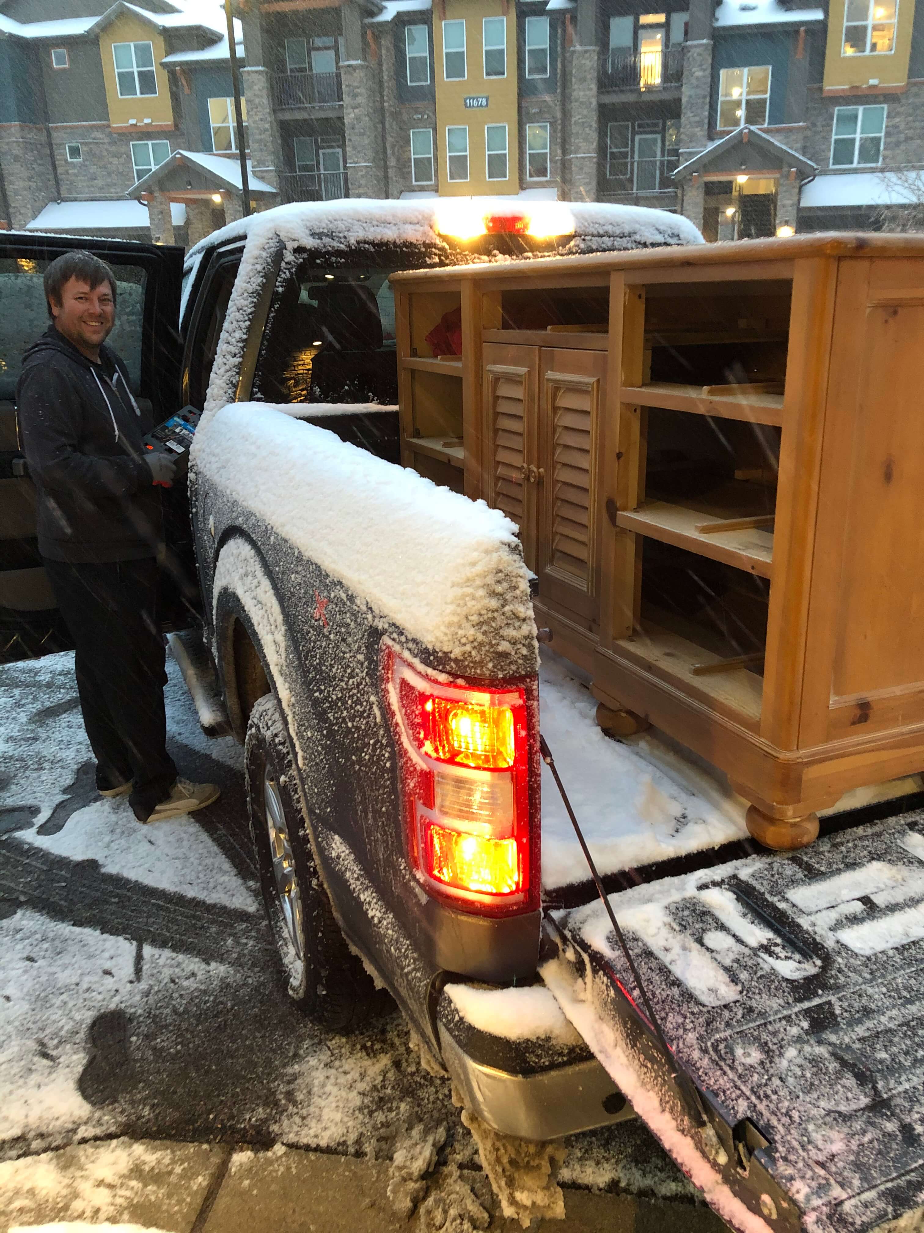 Snow covered truck with furniture in the back